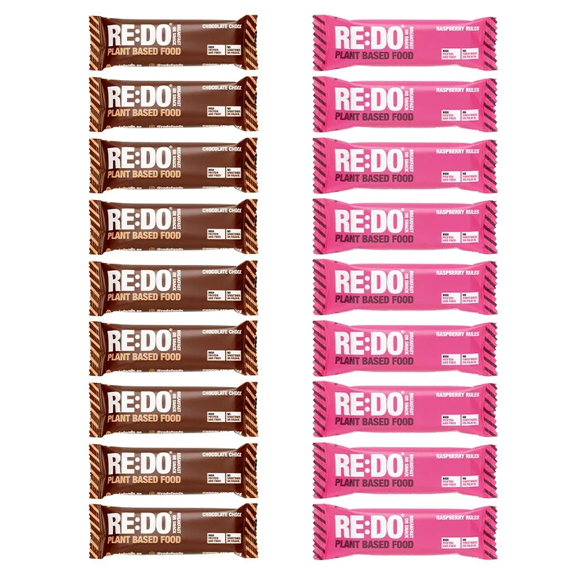 18 x REDO Bar 60 g Mixlåda med plantbaserade bars i bruna och rosa förpackningar för smakerna choklad och hallon.