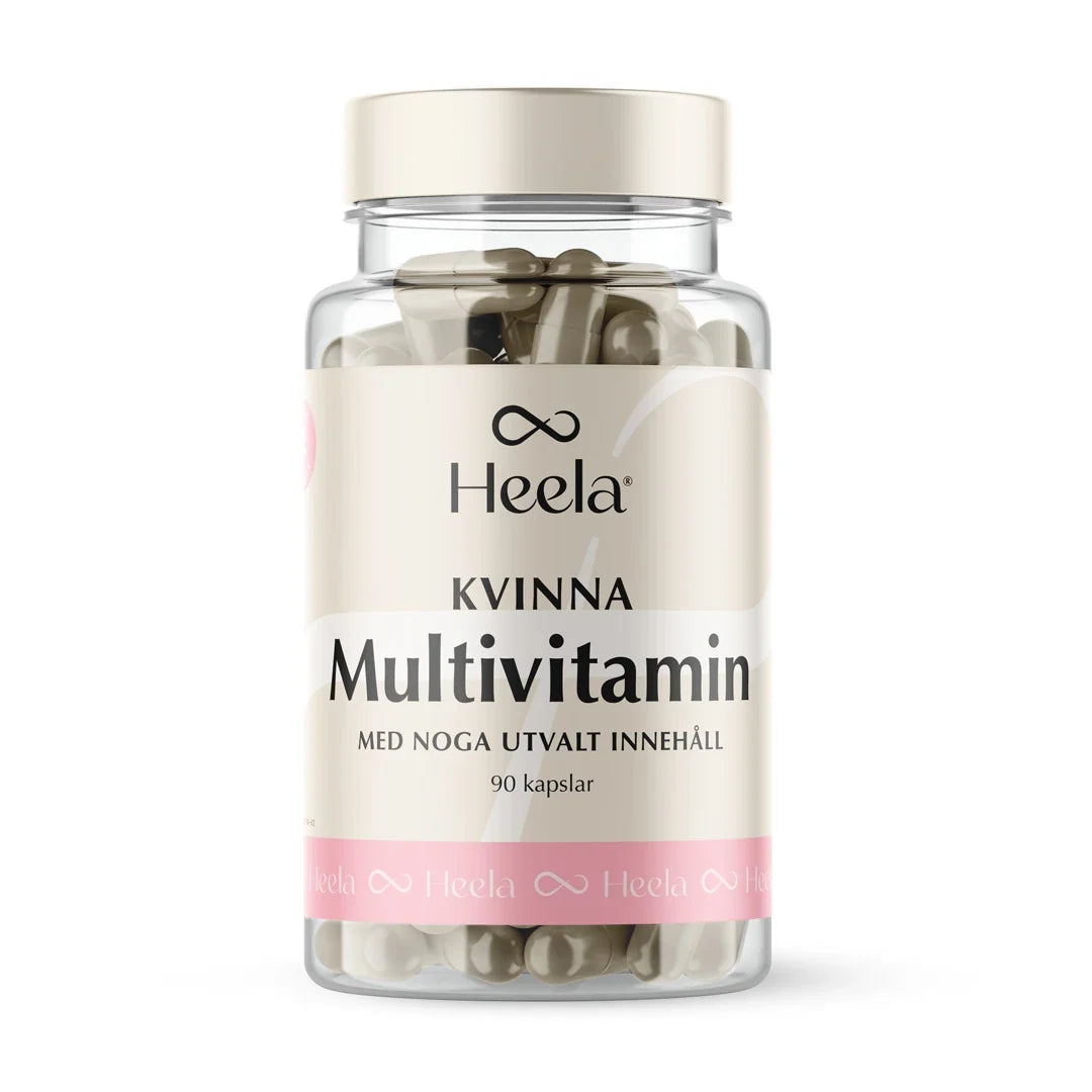 Heela Multivitamin Woman 60 caps i en genomskinlig burk med ljust lock och en beige etikett med rosa detaljer.