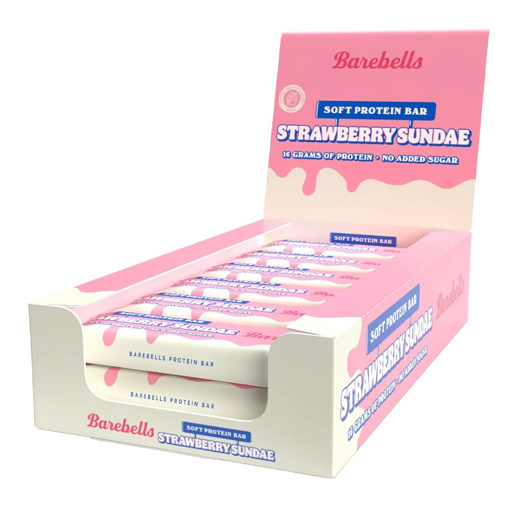12 x Barebells Soft Bar 55 g Strawberry Sundae i en rosa och vit låda med flera förpackade proteinbars inuti.