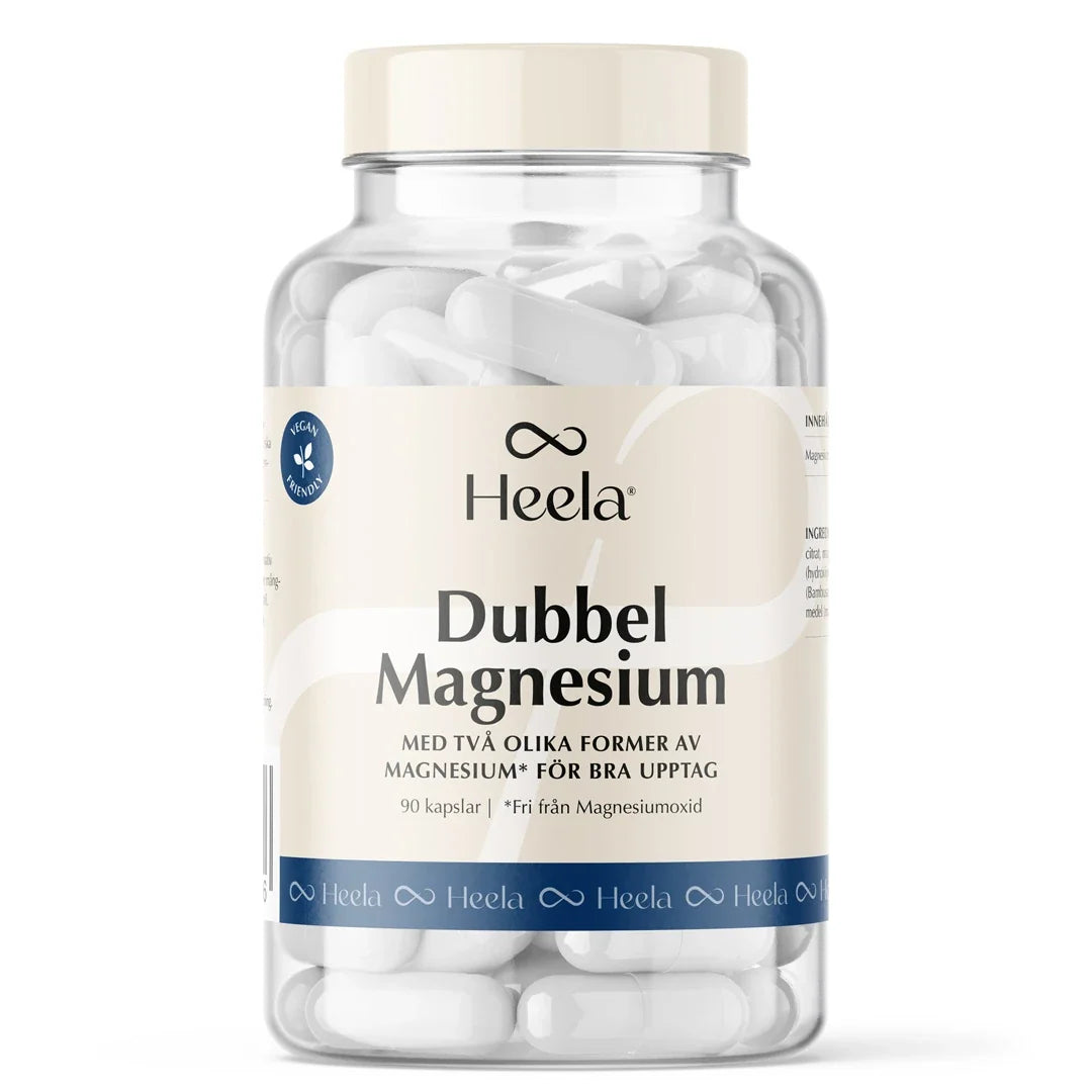 Heela Dubbel Magnesium 90 caps kosttillskott i en genomskinlig burk med ljus etikett, fylld med vita kapslar.