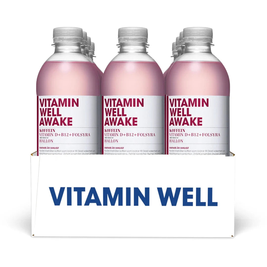 12 x Vitamin Well 500 ml Awake Hallon i ett vitt flak med genomskinliga flaskor, rosa dryck och vita etiketter.