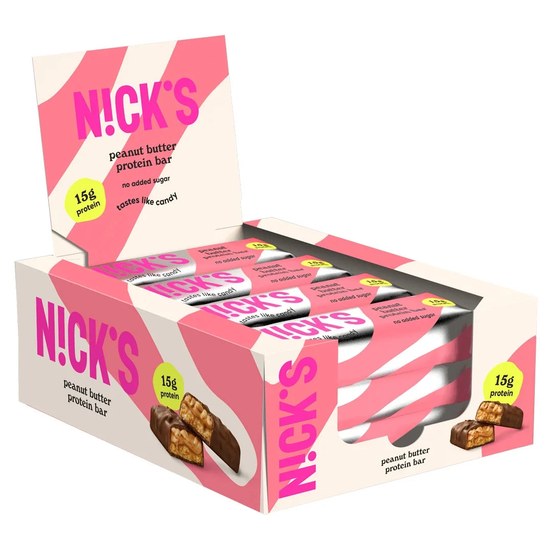12 x NICKS Soft bar 50 g Peanut Butter i en rosa och vit kartong med matchande förpackningar inuti.